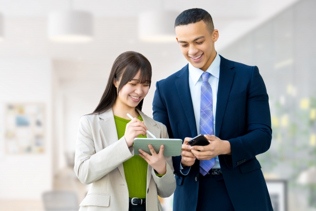 永住許可申請を考える外国人が、在職証明書、給与明細、前職の資料をタブレットで確認している様子