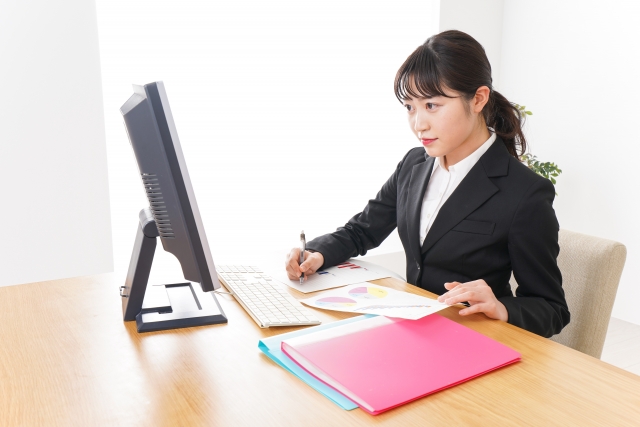 外国人雇用を進める企業の人事担当者が、雇用理由書、雇用契約書、職務記述書、会社案内を並べて就労ビザ申請の説明資料を確認している様子